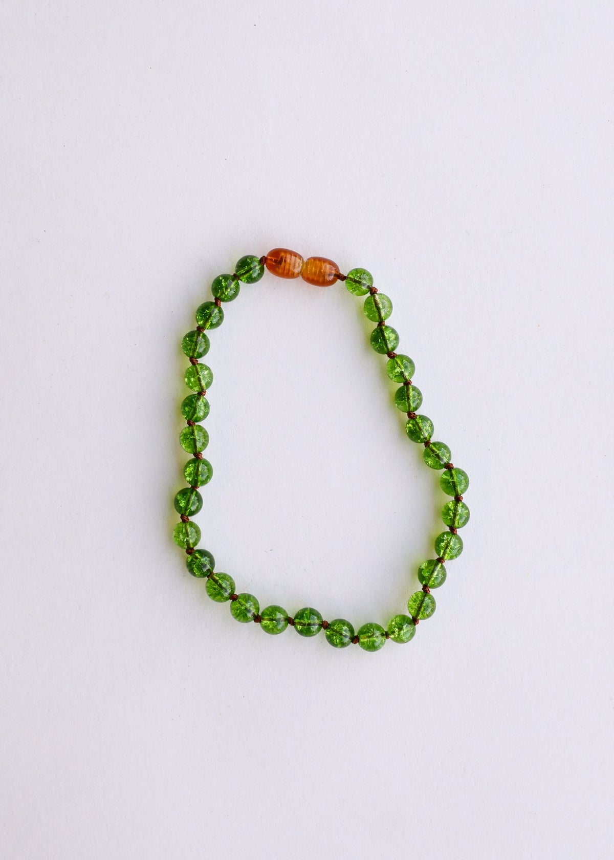 Round bead gemstone bracelet featuring green peridot stones and amber orange spacer beads