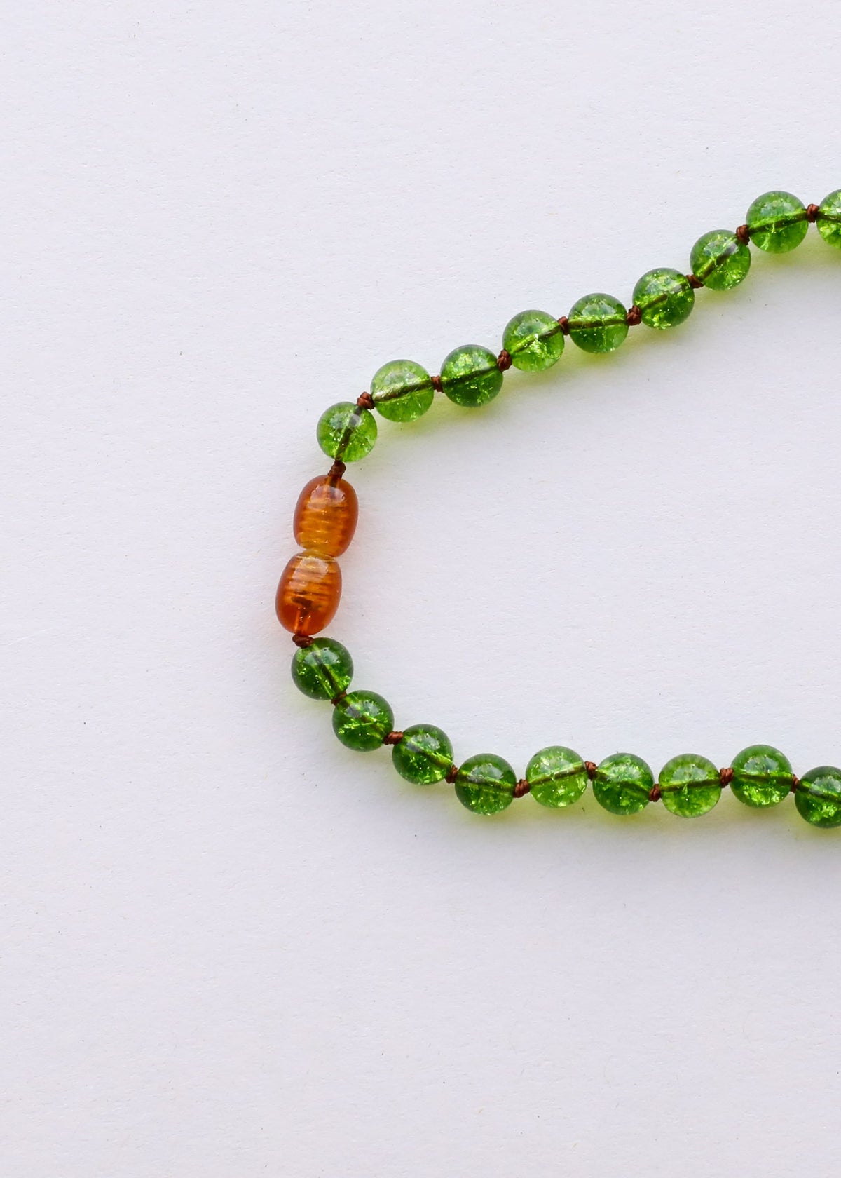 Close-up of green peridot bead bracelet with amber orange spacer bead details