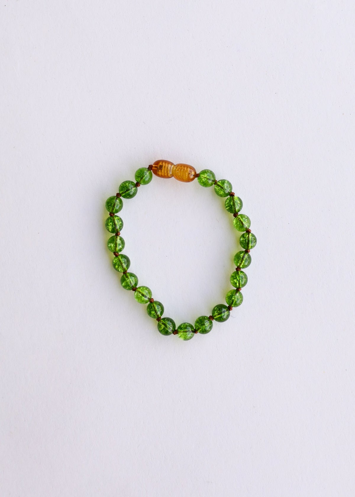 Peridot green gemstone bead bracelet with small amber accent beads, round stretch design