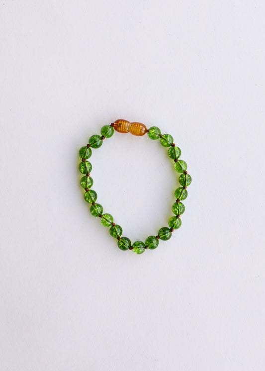 Peridot green gemstone bead bracelet with small amber accent beads, round stretch design