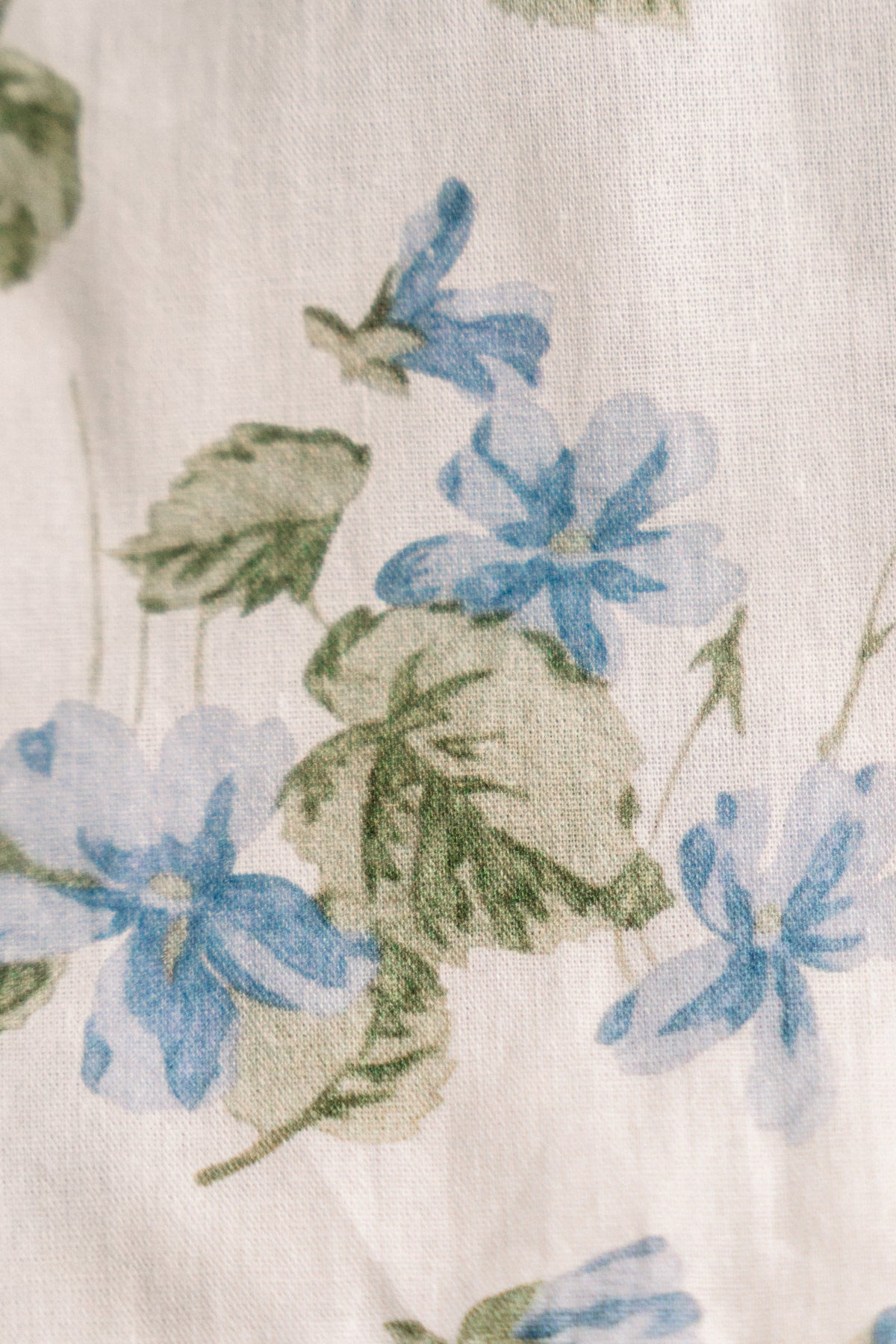 Close-up of cream fabric with blue and green floral botanical print