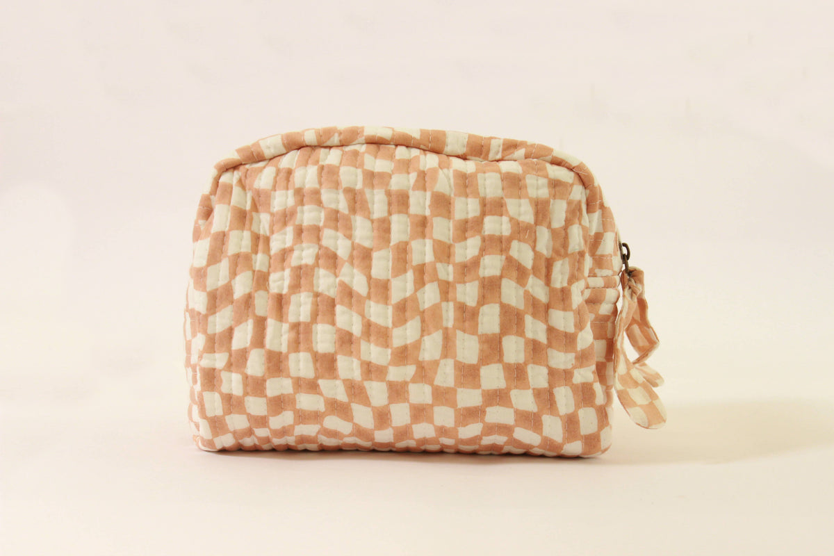 Handmade quilted pouch, peach-and-white checkered fabric, gathered top with tied tassel.