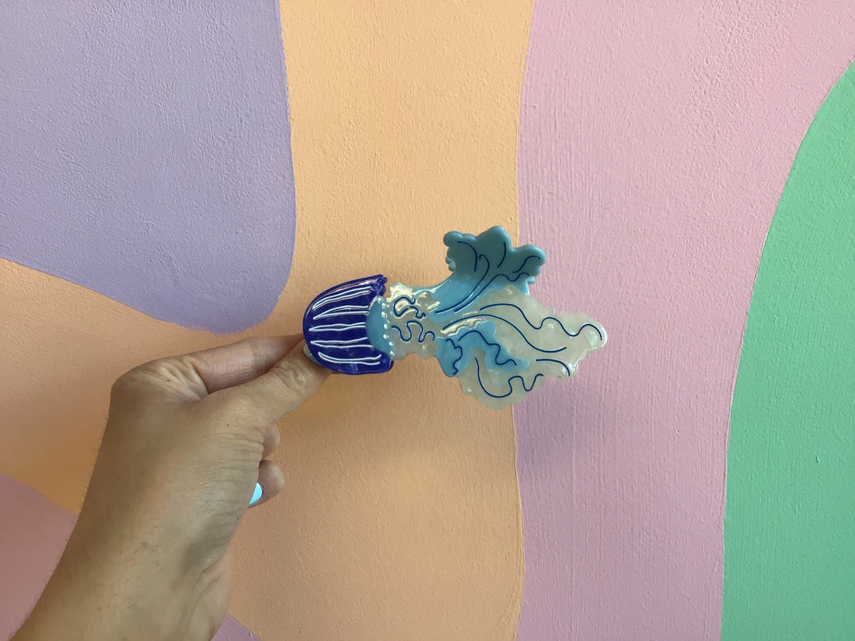 Light teal and white jellyfish hair claw with dark blue striped underside