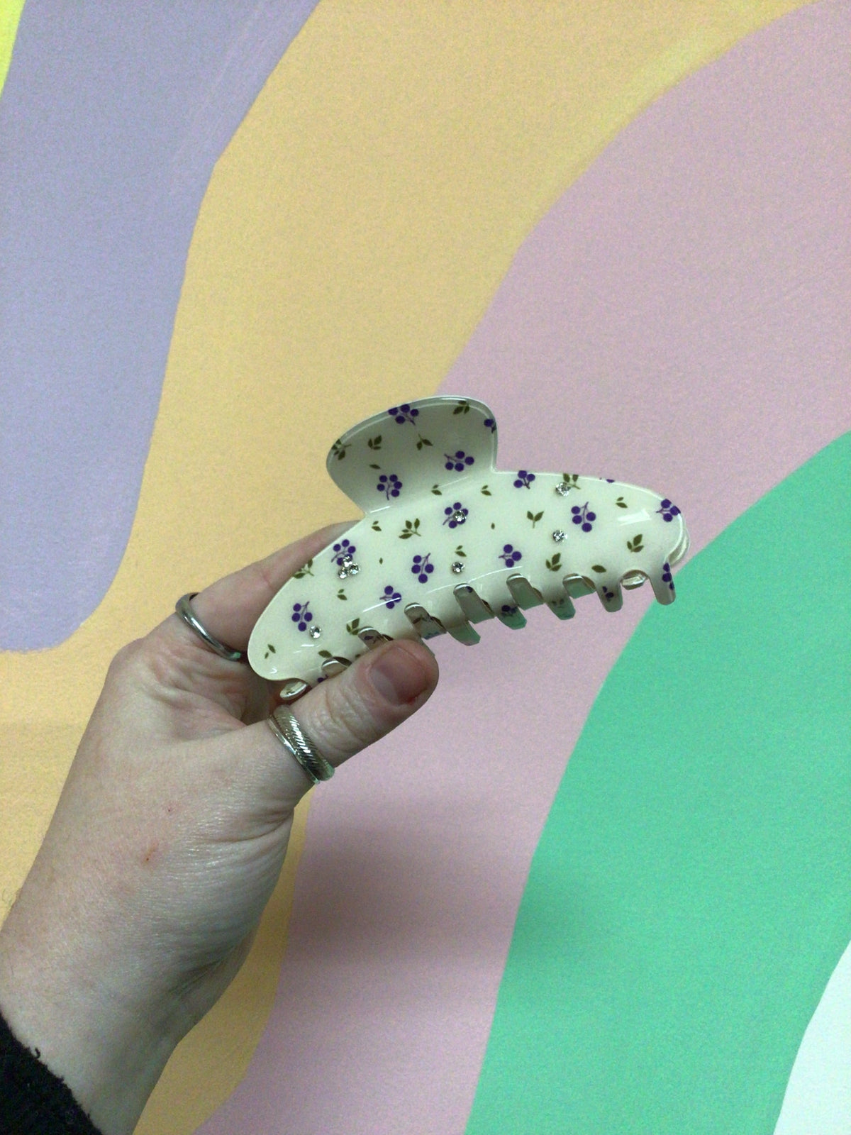 Cream toile hair claw clip with small blue and purple floral print and curved teeth