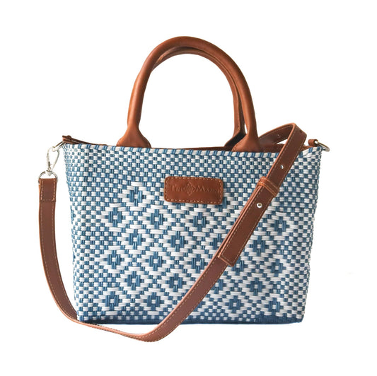 Woven crossbody bag in blue-and-white woven pattern with tan leather handles and logo patch