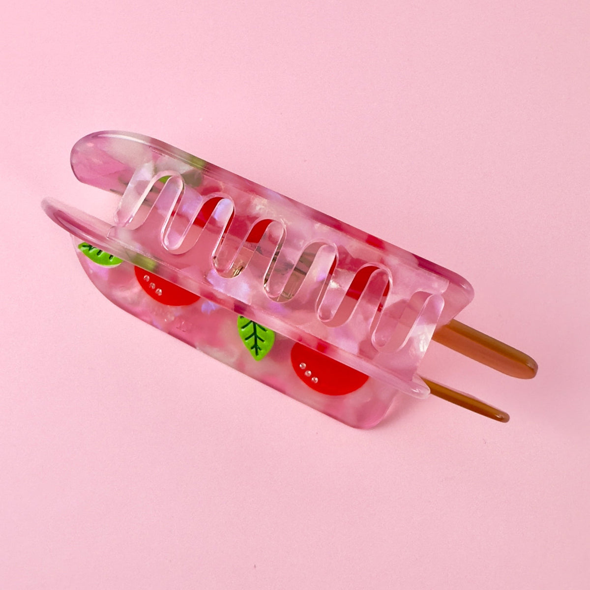 Translucent pink cherry popsicle hair claw with red cherry charms and clear teeth comb