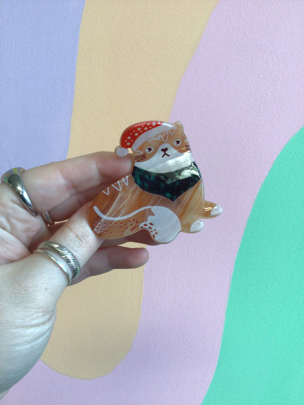 Festive cat hair claw with orange cat figure and red dotted cap