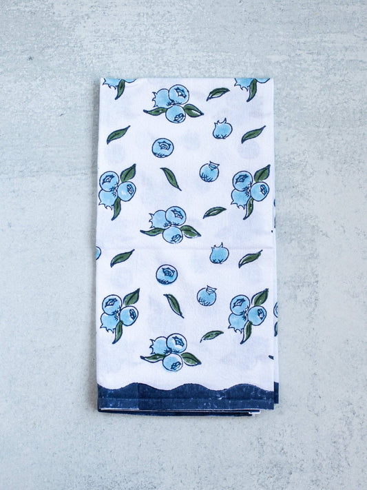 Blueberry tea towel, white with scattered blue berries and green leaves, folded