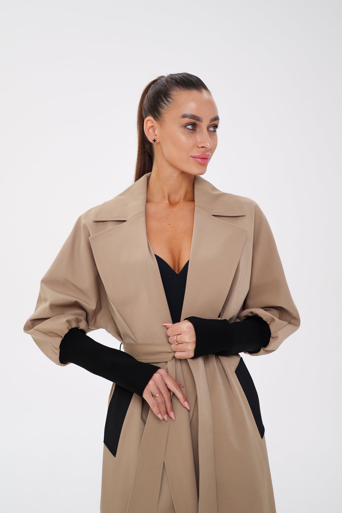 Miru camel trench coat detail with wide lapels, gathered sleeves, and black pocket trim