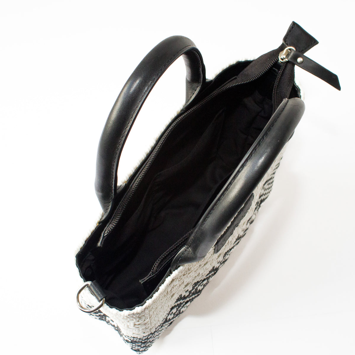 Small woven crossbody bag open to show black zipper and dark interior lining