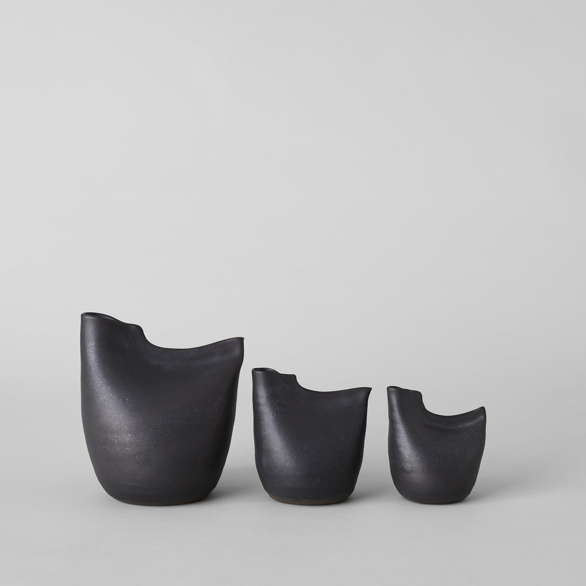 Matte black bird vases, three sizes with smooth curved bodies and open tops.