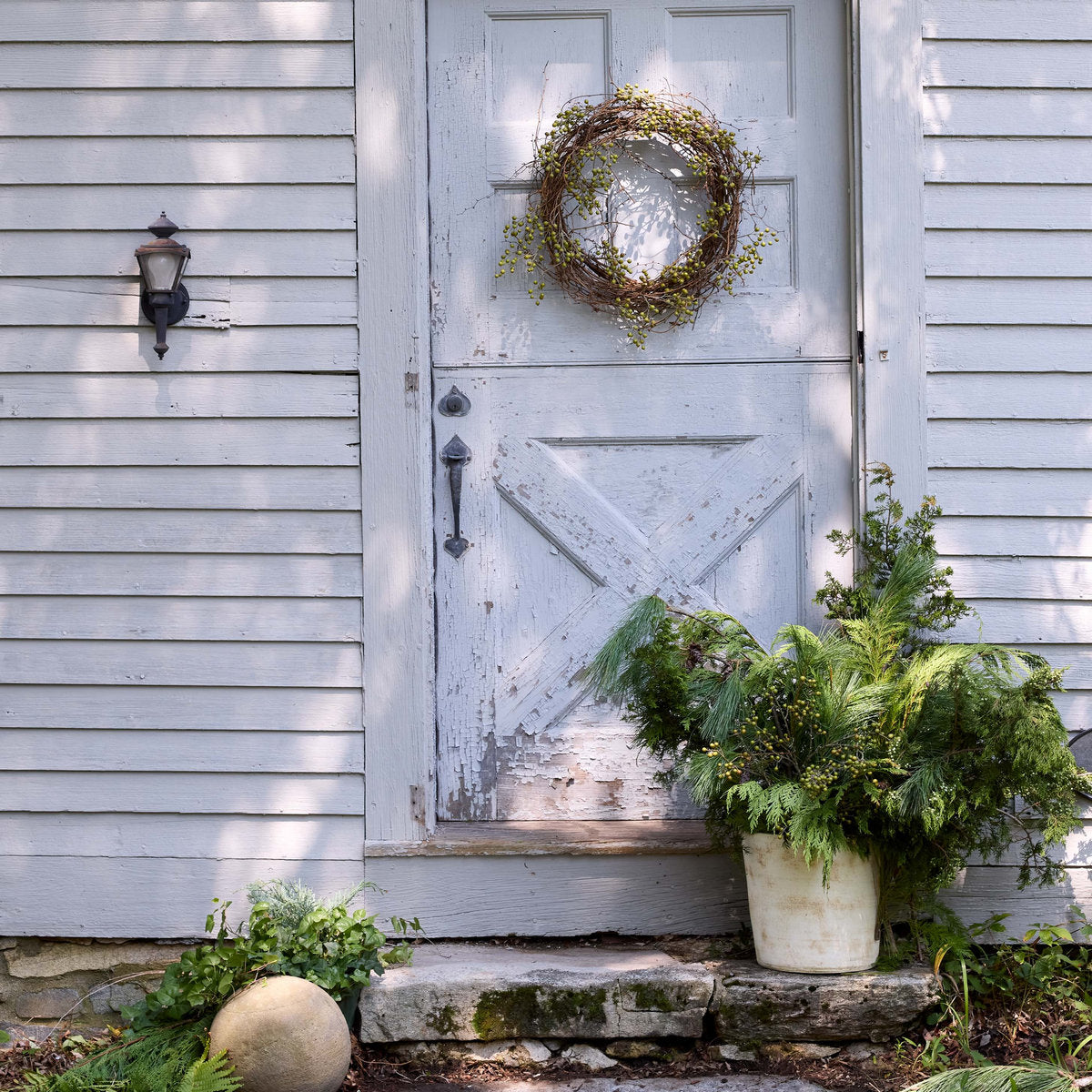 White patina terra-cotta planter with dense greenery on a porch step