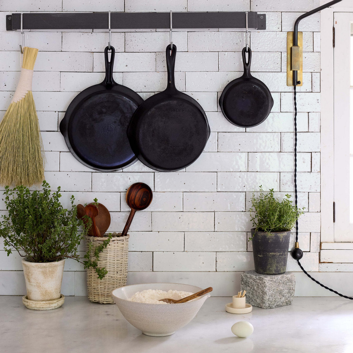 Multiple grey patina terra cotta planters with small plants, different heights