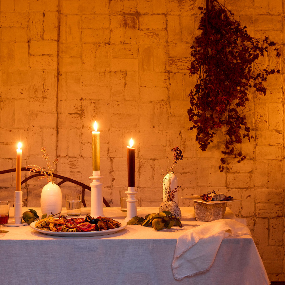 White linen tablecloth spread on a candlelit table