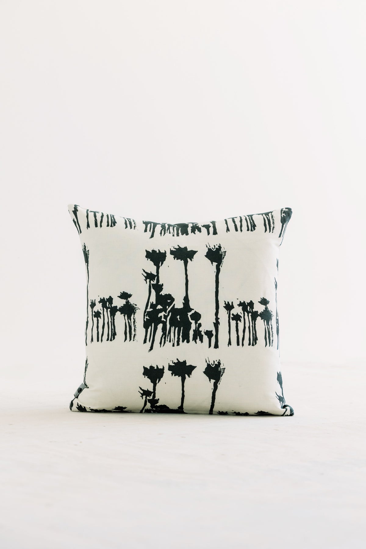 Bosque 18x18 throw pillow with black animal silhouettes on white fabric
