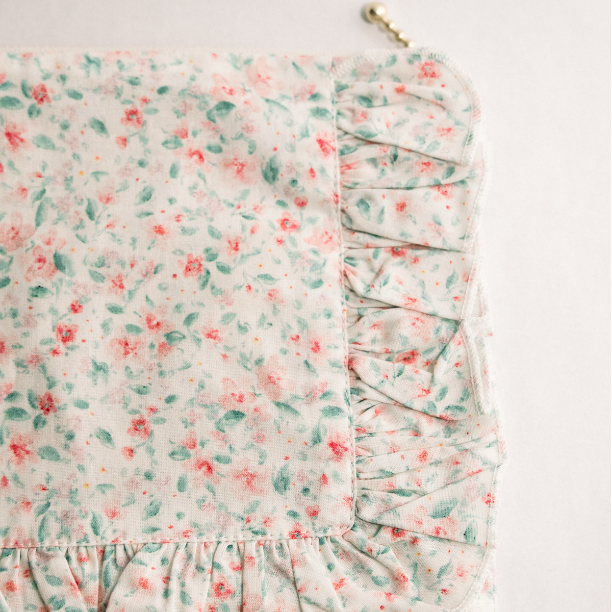 Pastel floral ruffle zip pouch detail with pleated side trim and zipper track