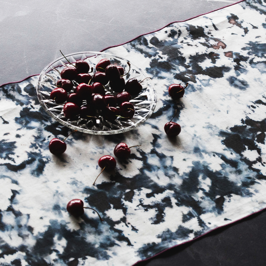 Grey marble-pattern runner with maroon border trim, top surface close-up