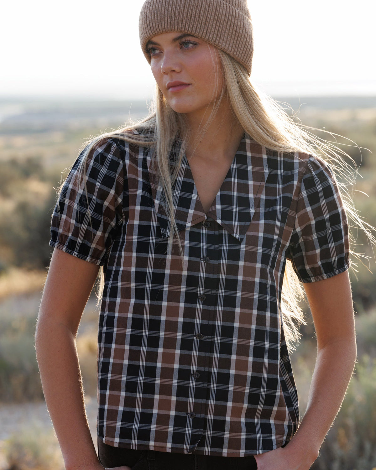 Short-sleeve plaid button-down shirt in dark tones with tan and white checks