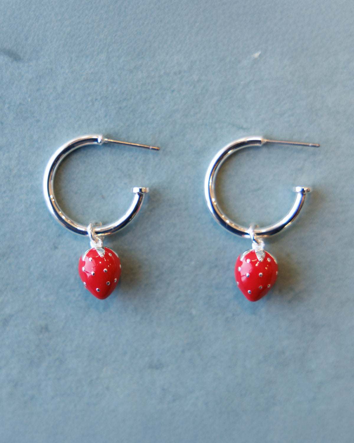 Silver hoop earrings with red strawberry charm dangles