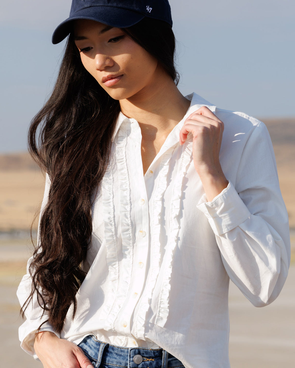 White button-down shirt with ruffled vertical placket and long sleeves
