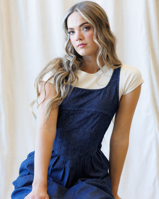 Medium blue wash denim pinafore dress with sleeveless square neckline and gathered bodice