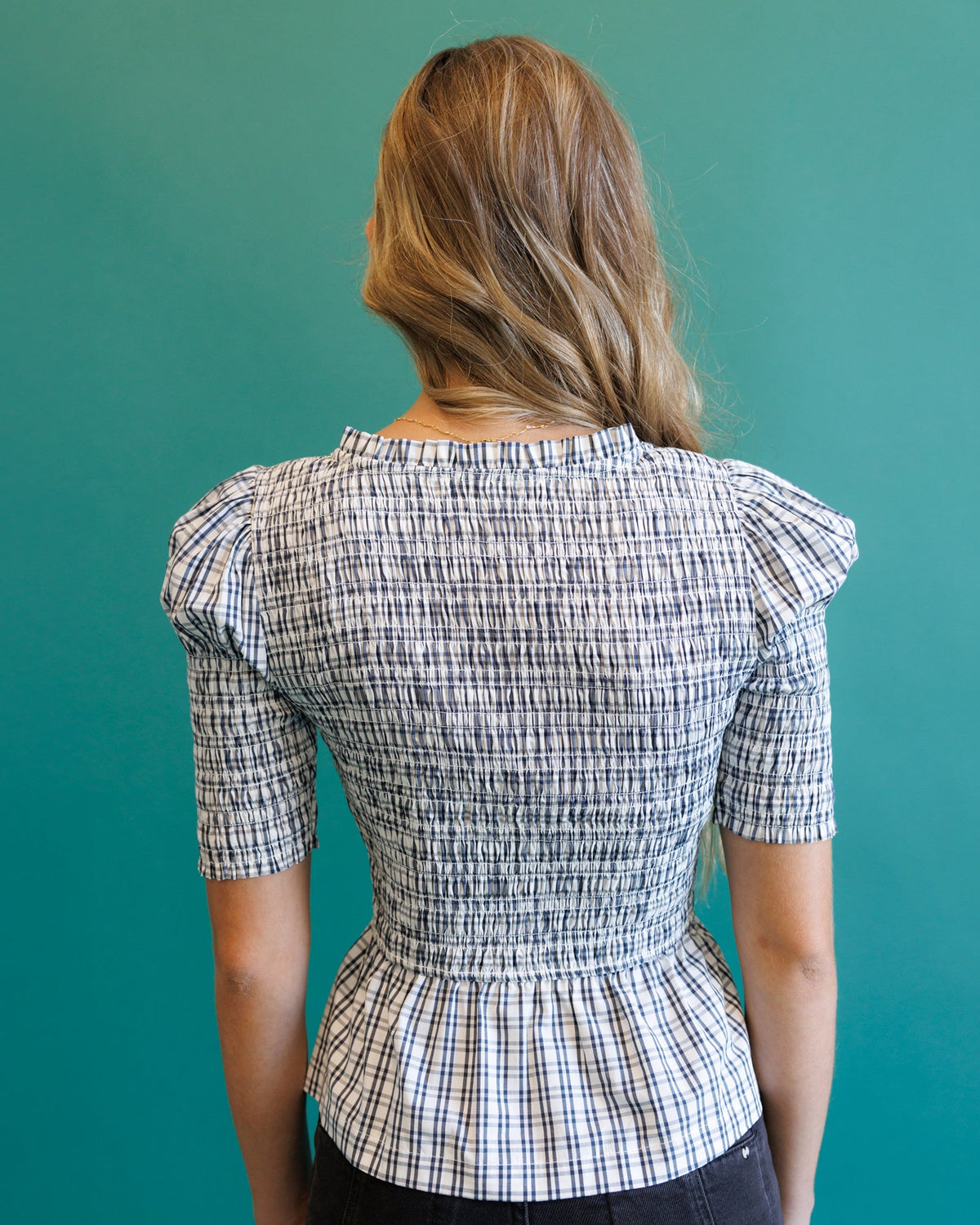 Plaid peplum blouse back view with gathered waist and buttoned yoke