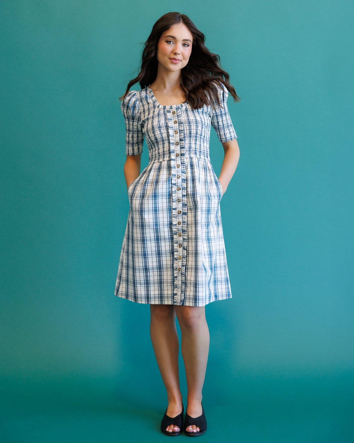 Cream and blue plaid oxford dress with short puff sleeves and button-down bodice.