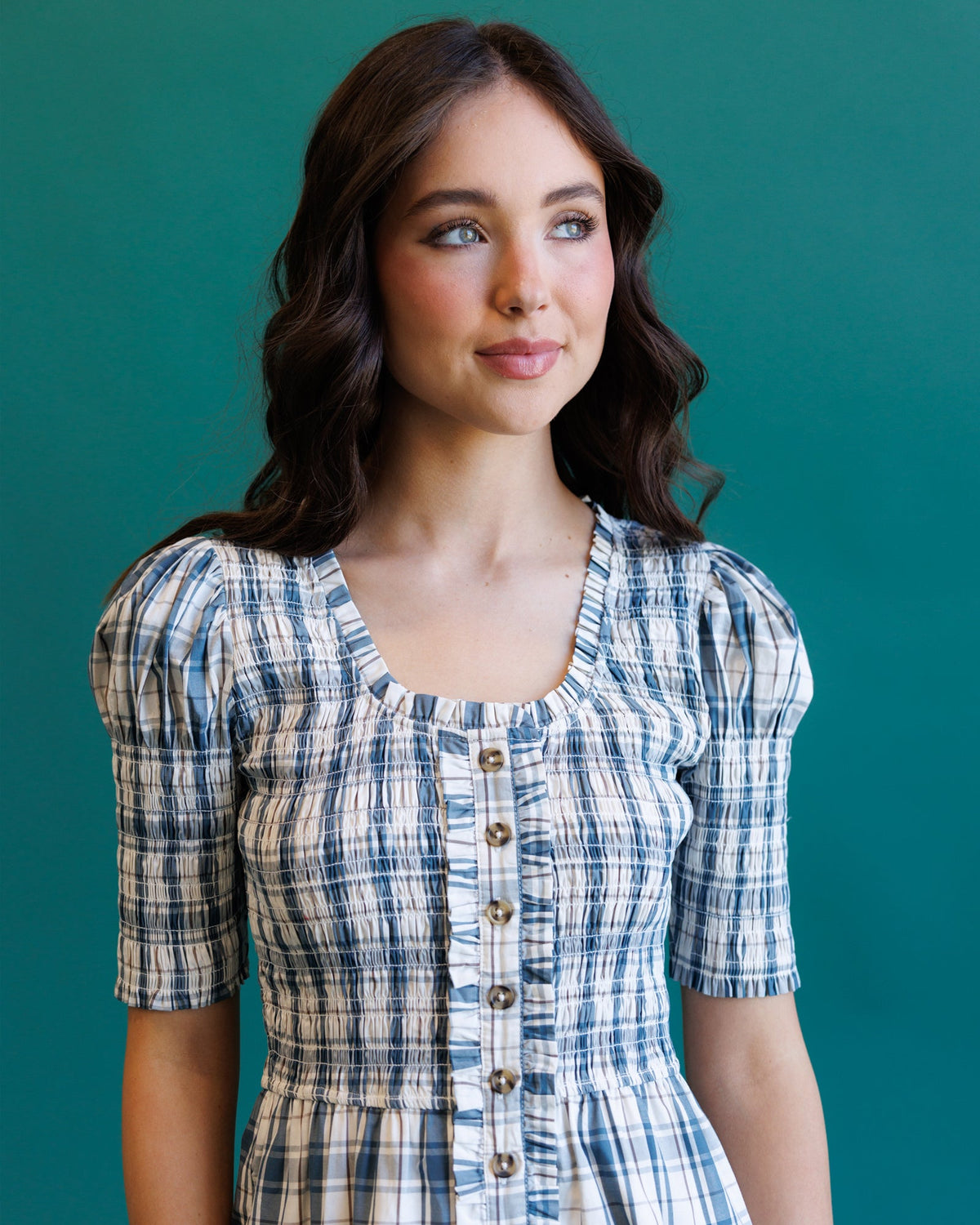 Close-up of cream and blue plaid oxford dress bodice with buttons and elastic waist.