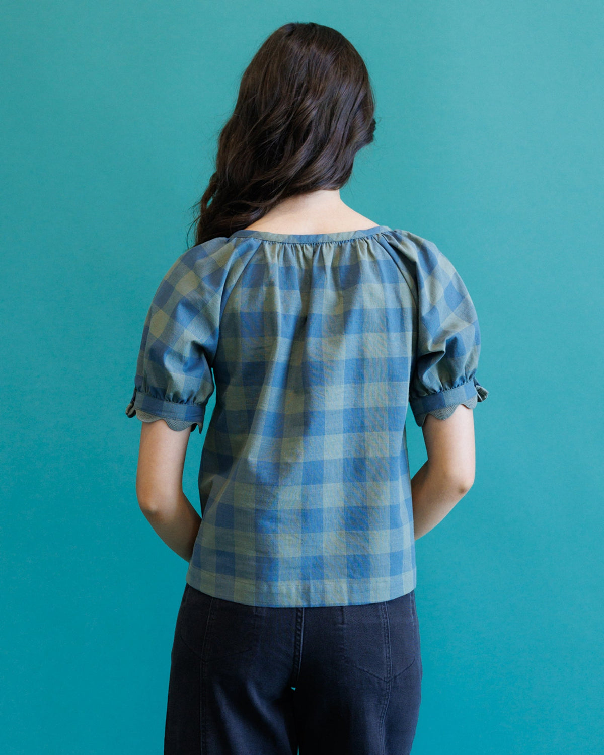 Back view of blue and gray checked short-sleeve top with gathered yoke