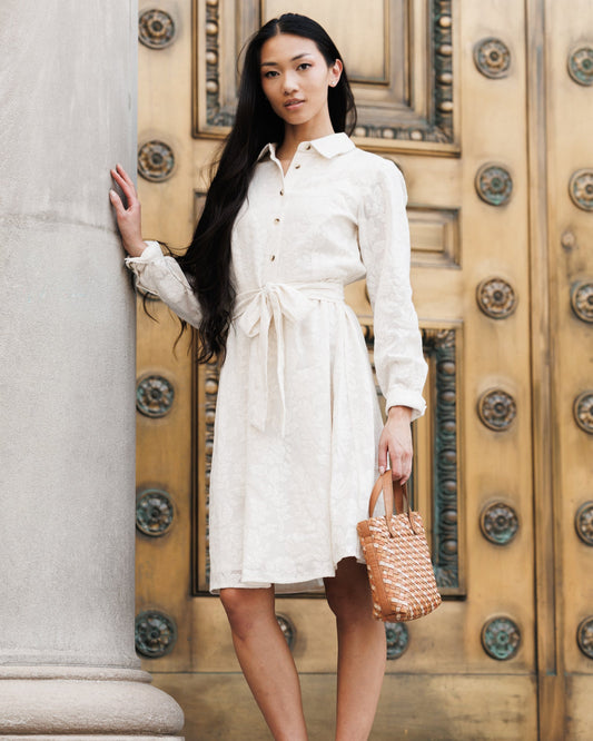 White button-front shirt dress with long sleeves and tied waist belt, midi length