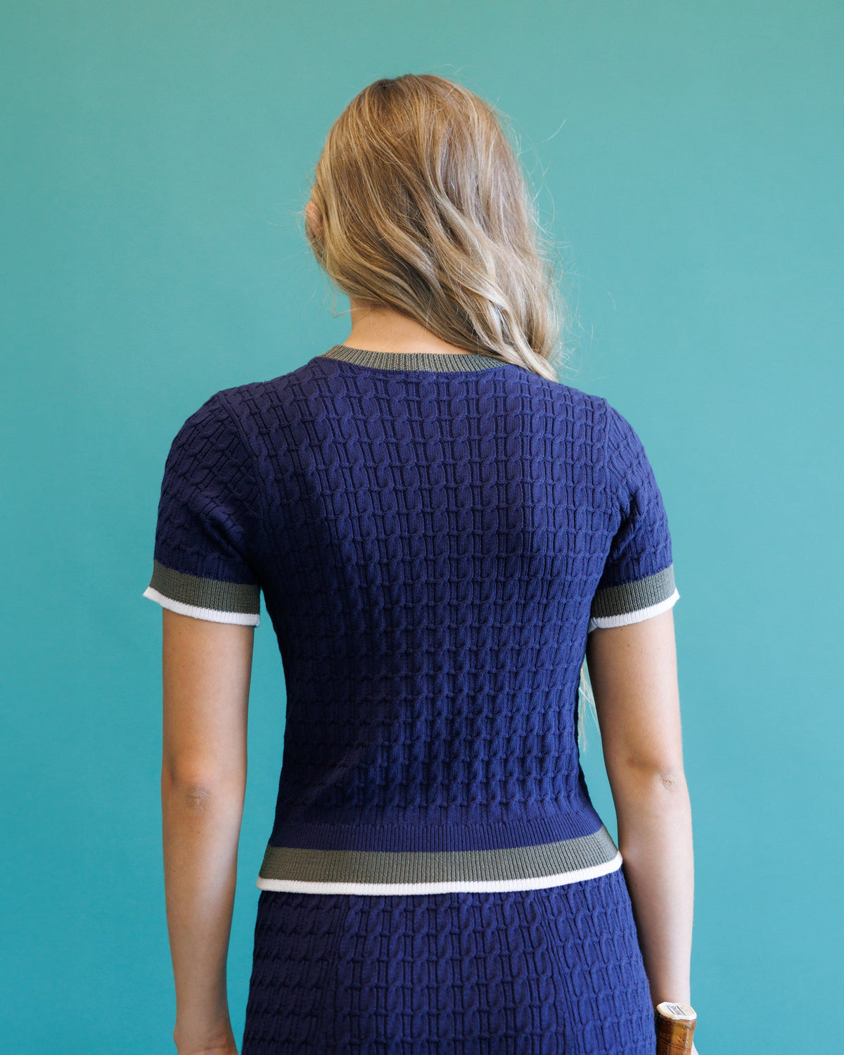 Dark blue cable-knit crew sweater, back view, ribbed hem and collar trim