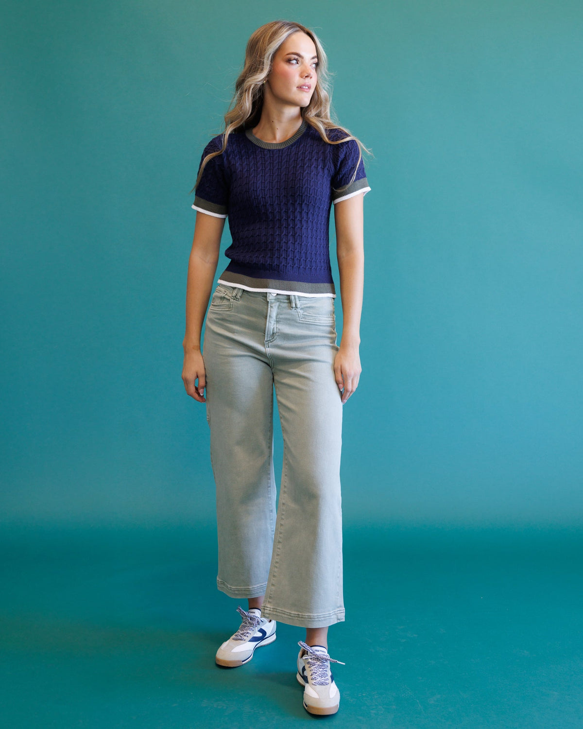 Dark blue cable-knit crew sweater with short sleeves and light striped ribbed neckline