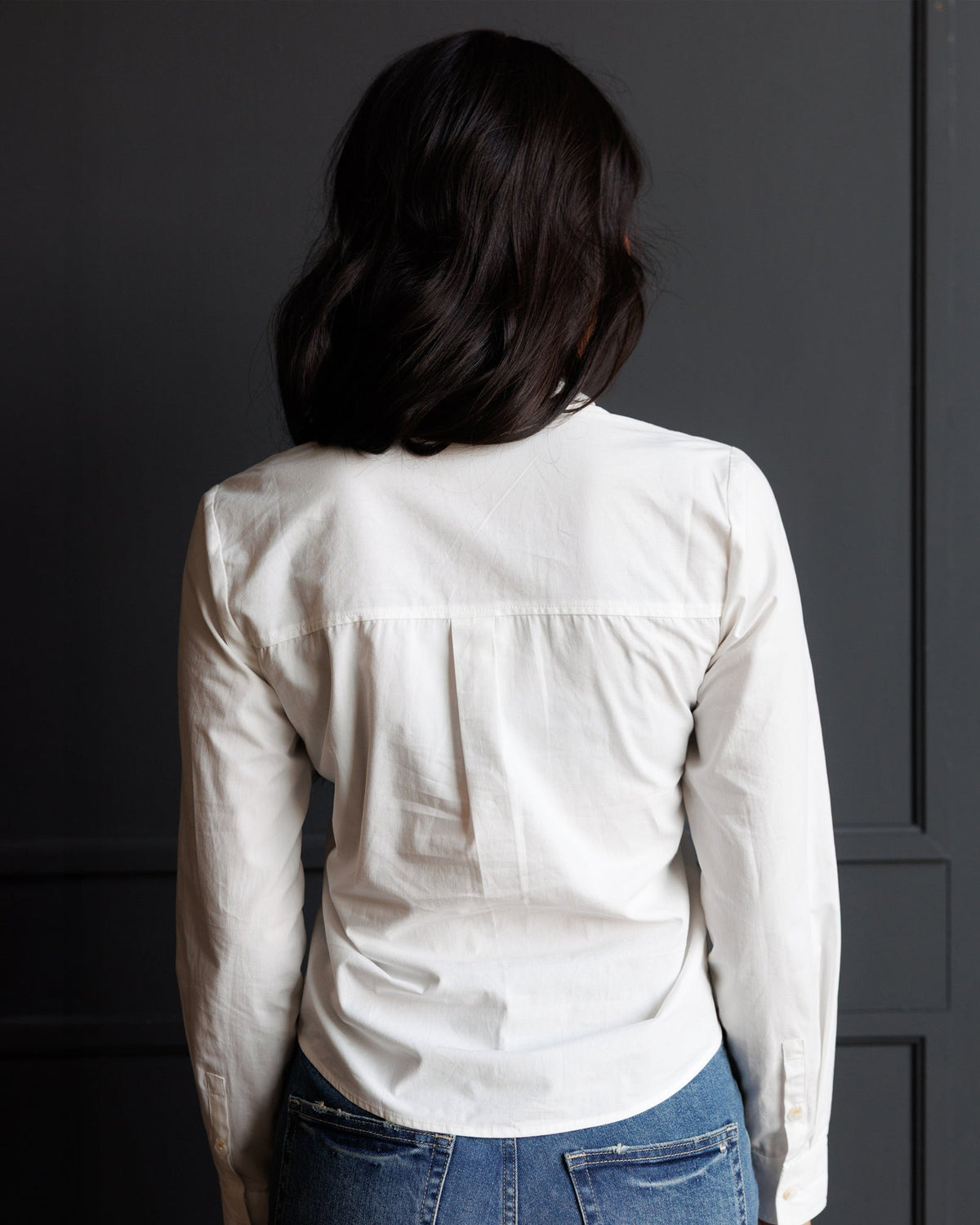 White button-down shirt back view with yoke seam and curved hem