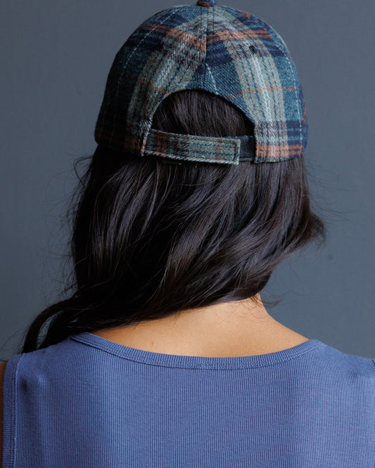 Plaid newsboy cap with open back panel and strap, dark blue and orange tones
