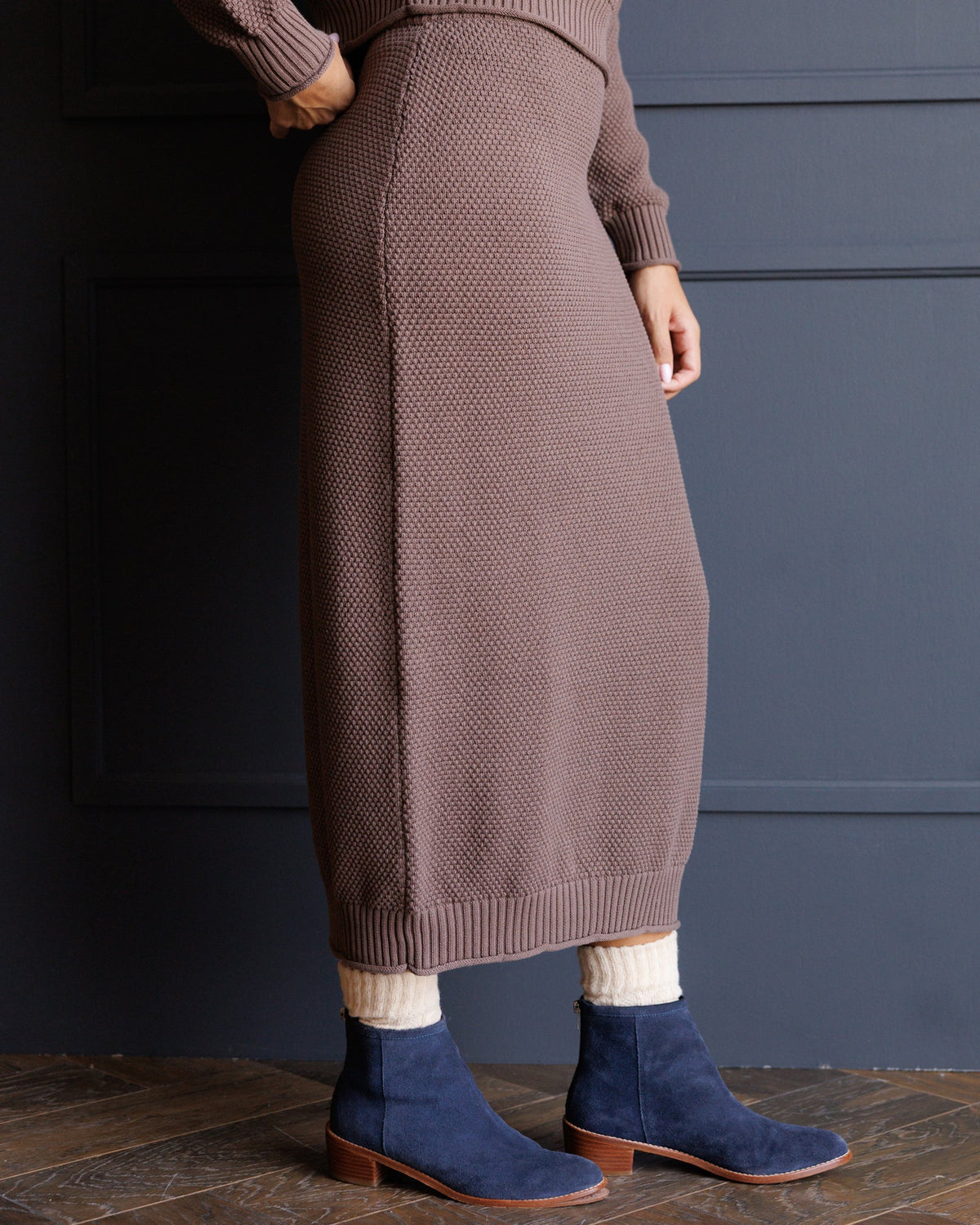 Brown knit midi skirt with ribbed hem and textured knit pattern on fabric
