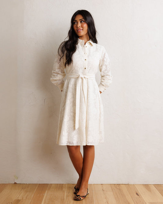 White shirt dress with button placket, long sleeves, and gathered tie waist, midi length