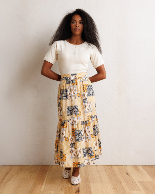 Tiered patchwork midi skirt with orange-cream base and navy patterned blocks
