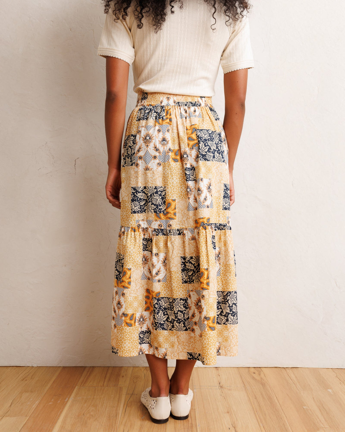 Tiered patchwork midi skirt with elastic waistband and orange-cream navy print