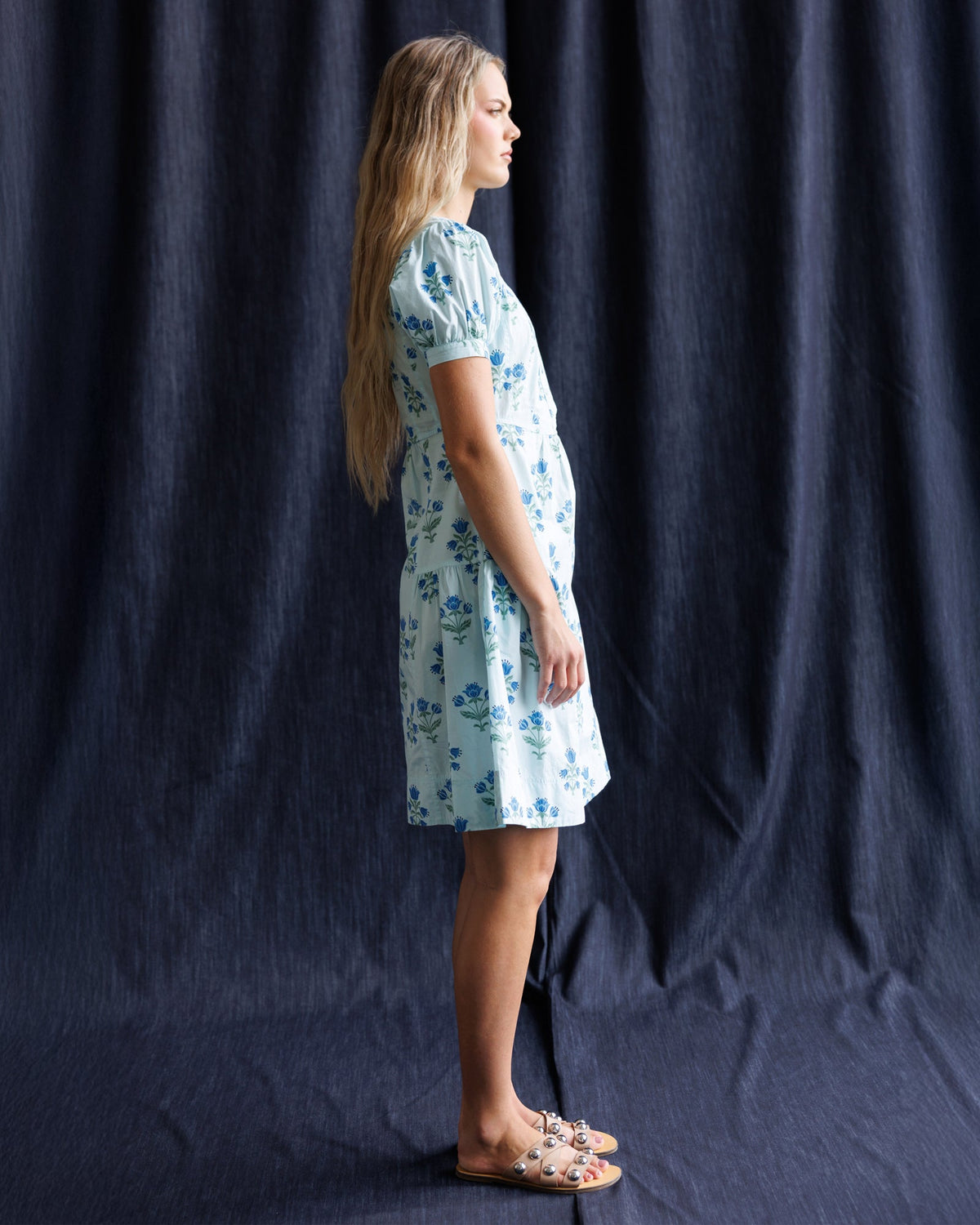White floral print dress with blue puff sleeves, side view, above-knee hem