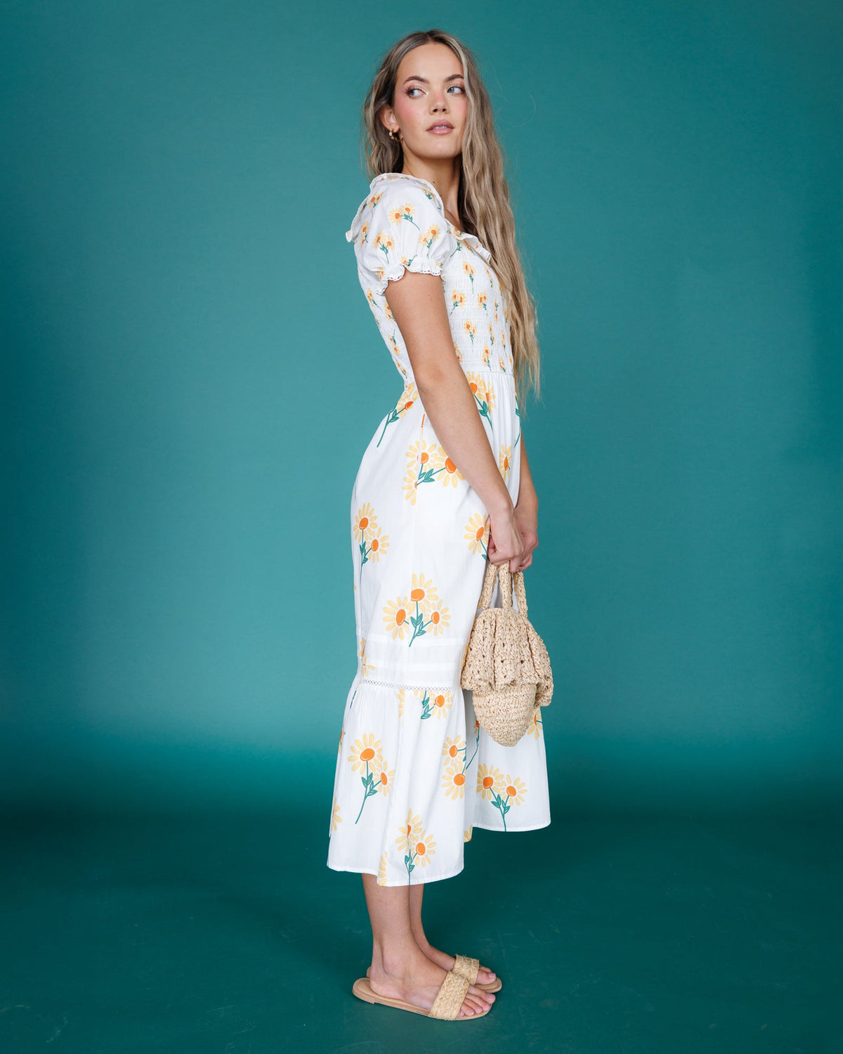Three-quarter view of white floral tiered midi dress with puff sleeves