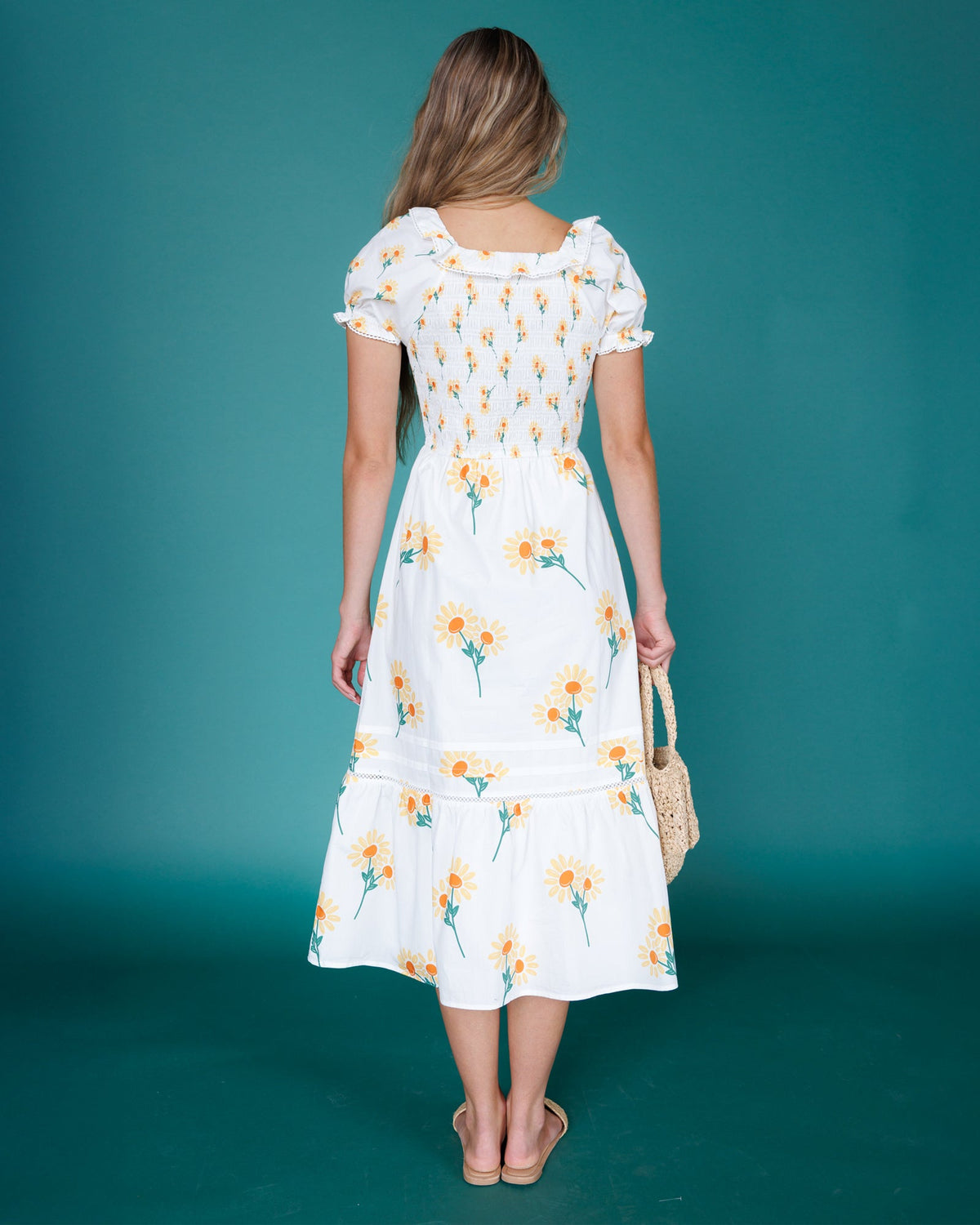 Back view of white floral tiered midi dress with puff sleeves and button detail