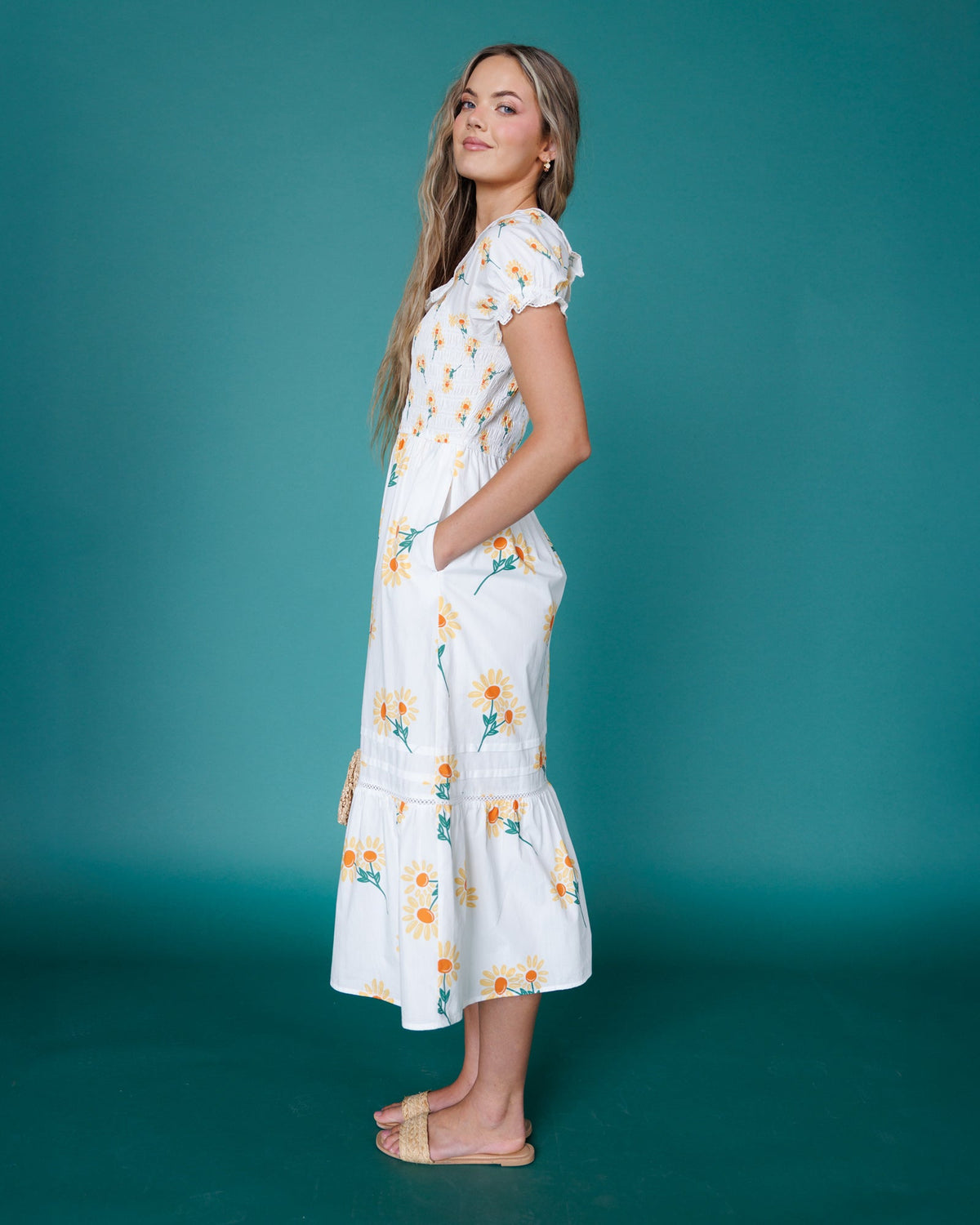 Side view of white floral midi dress with tiered skirt and puff sleeves