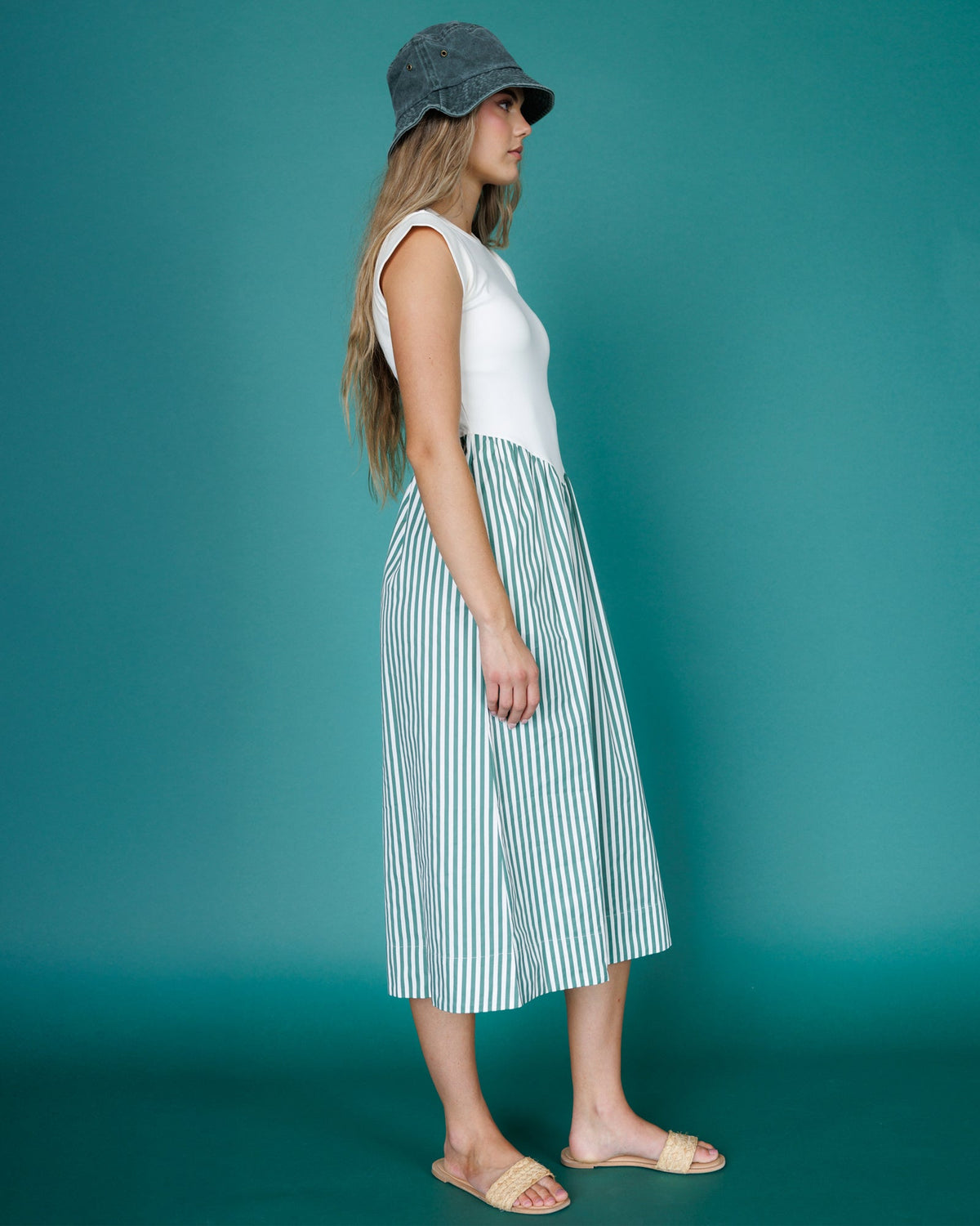 Side view sleeveless midi dress with white bodice and vertical blue-green striped skirt