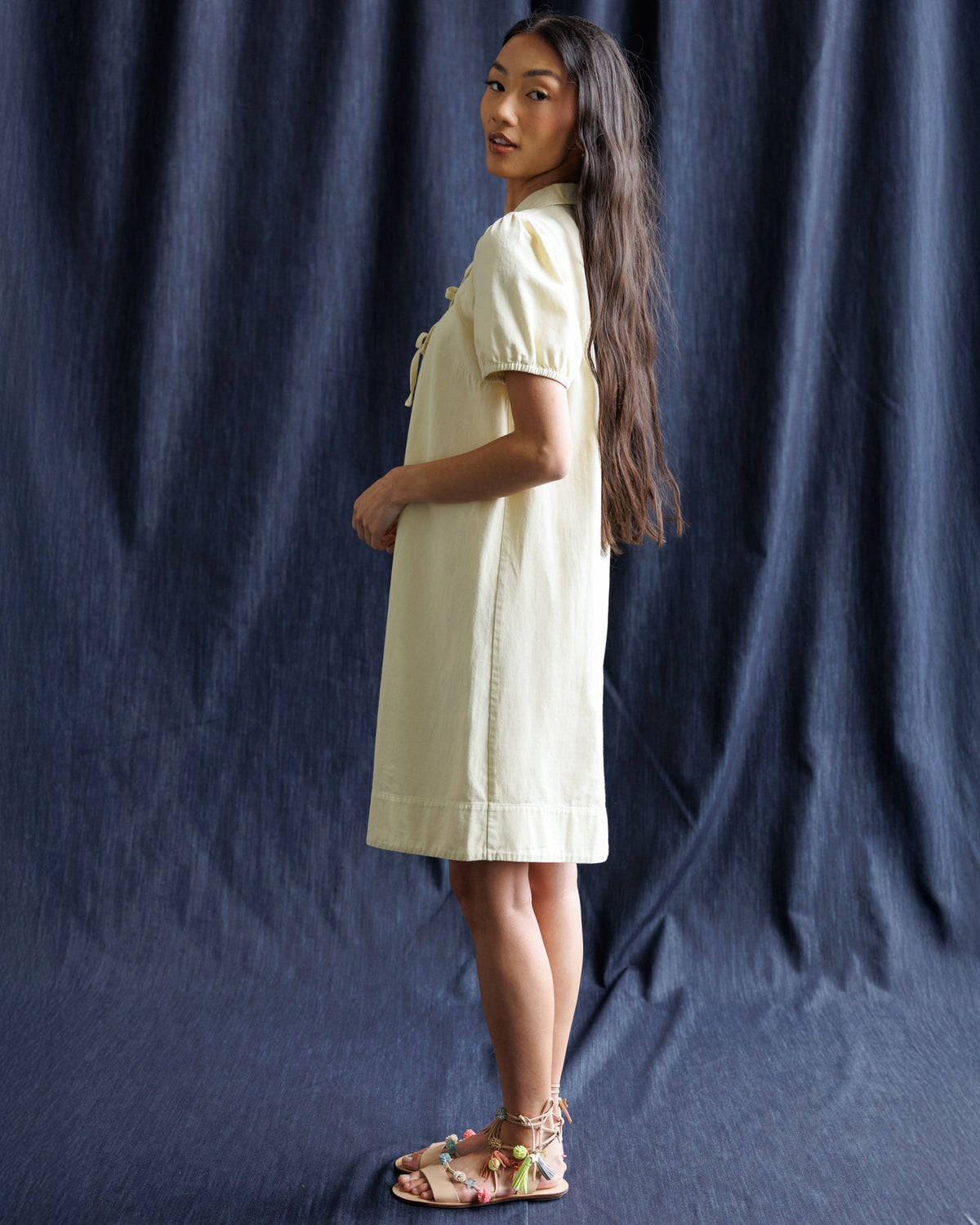 Light yellow denim dress with collared ribbon bow, short sleeves, side view