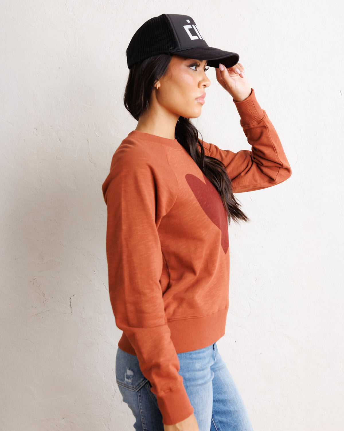 Copper brown crewneck sweatshirt with heart graphic, side view