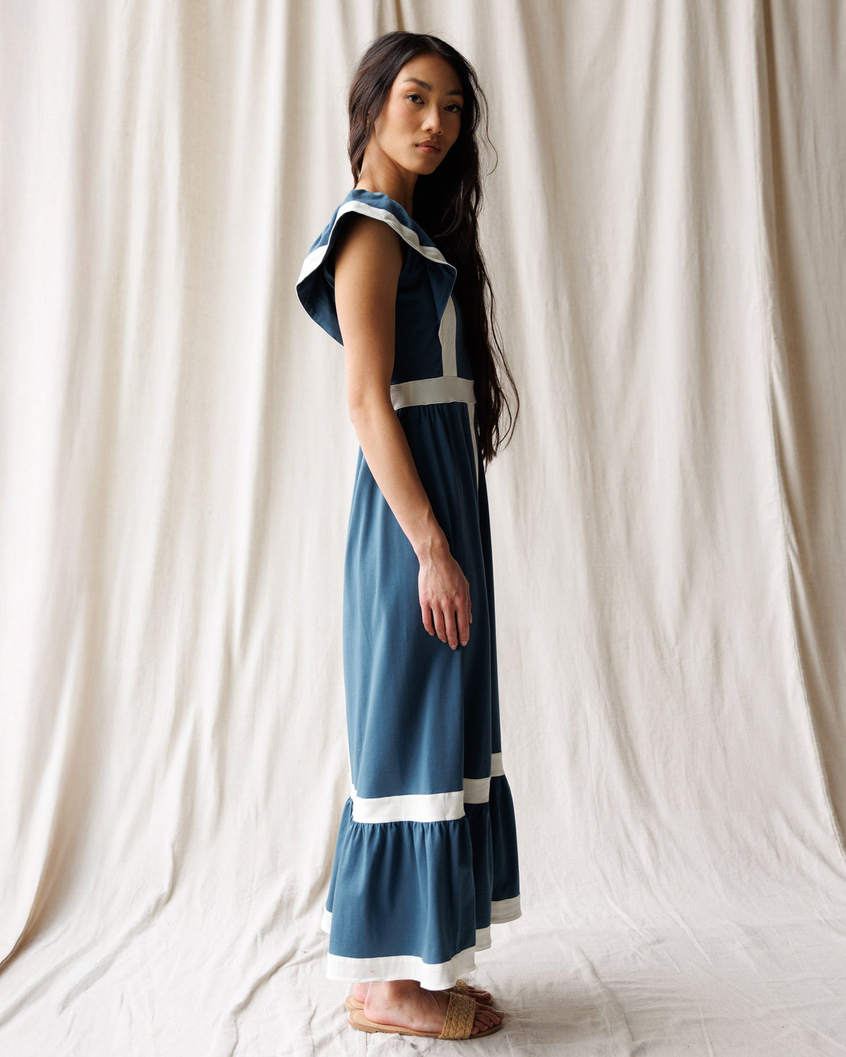Side view of women’s Block Party dress in blue with white trim panels and tiered bottom