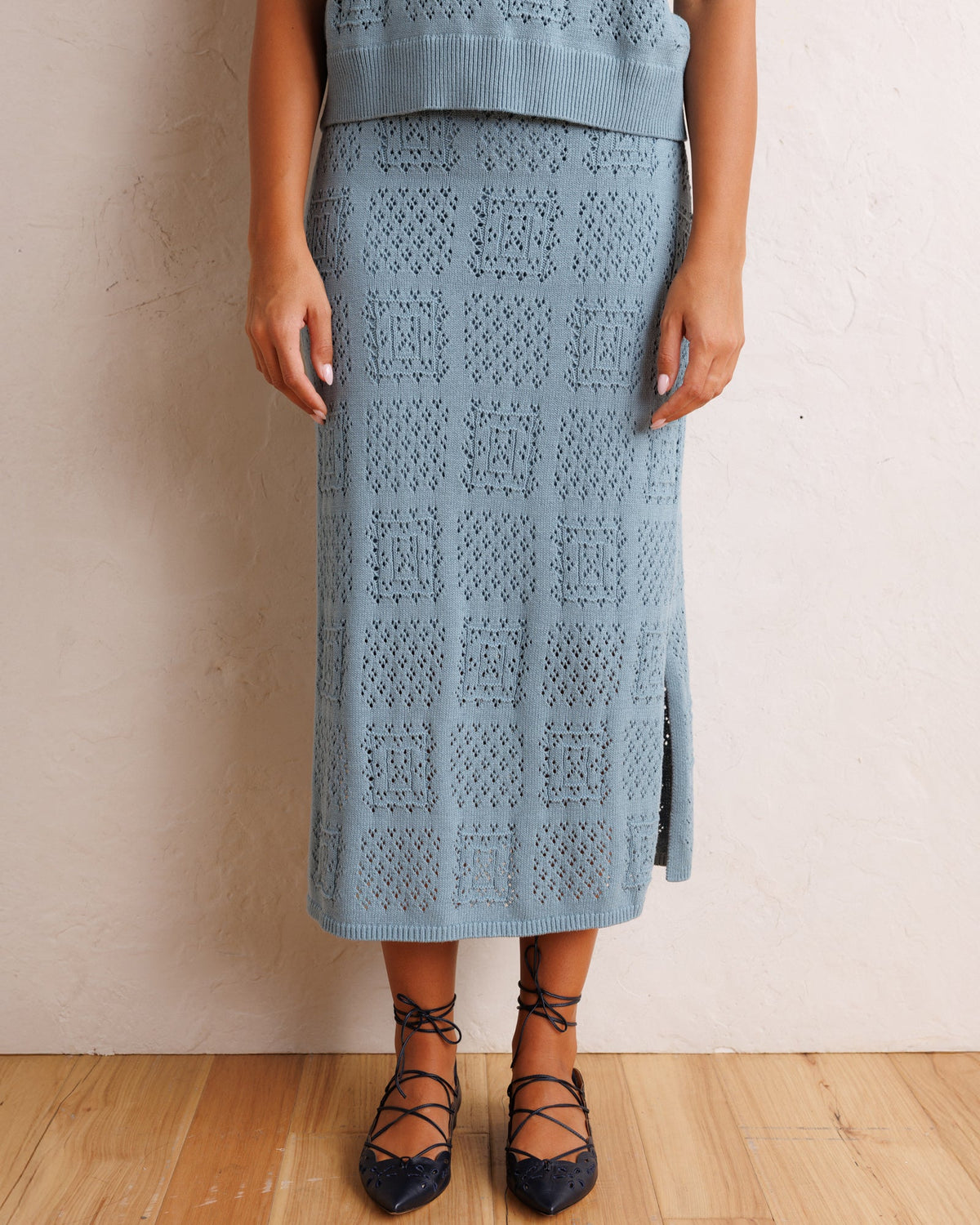 Smoke blue textured knit midi skirt with front slit and allover geometric design