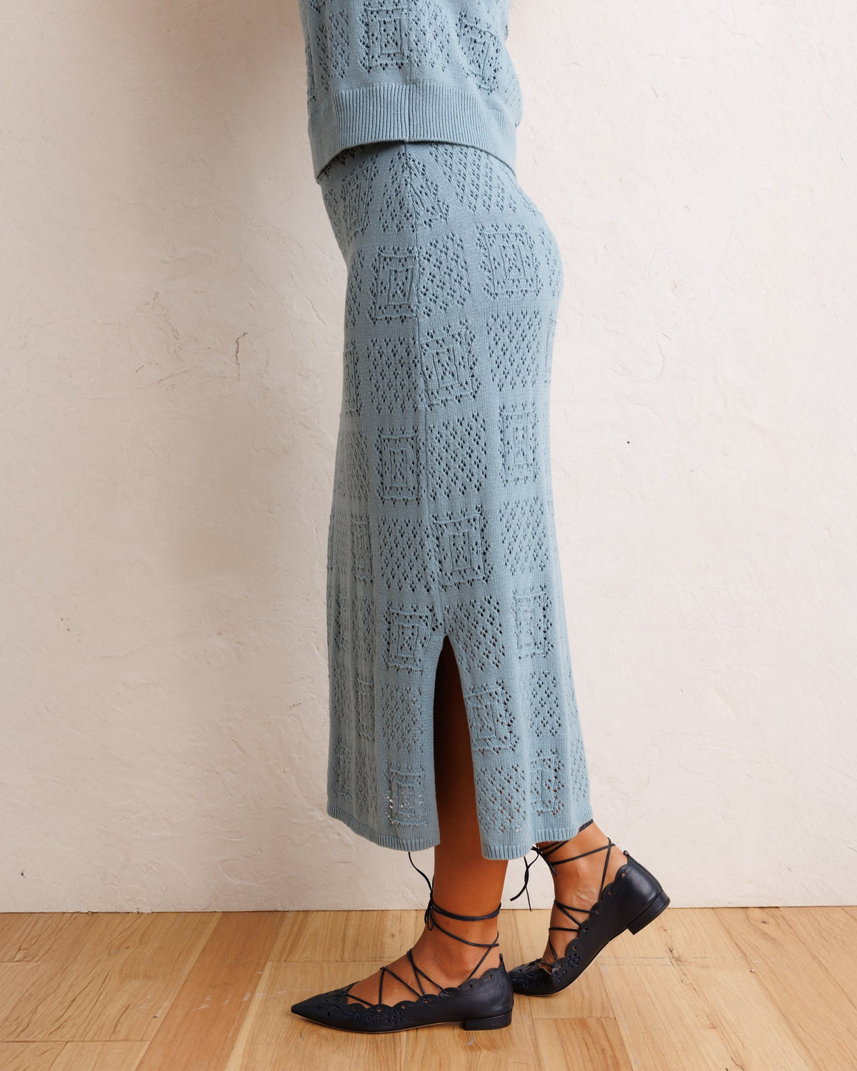 Smoke blue knit midi skirt with front slit and allover geometric pattern