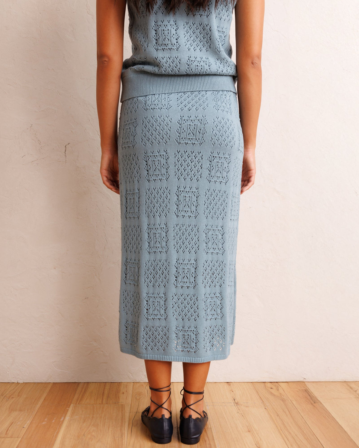 Smoke blue textured knit midi skirt with front slit and straight pencil silhouette
