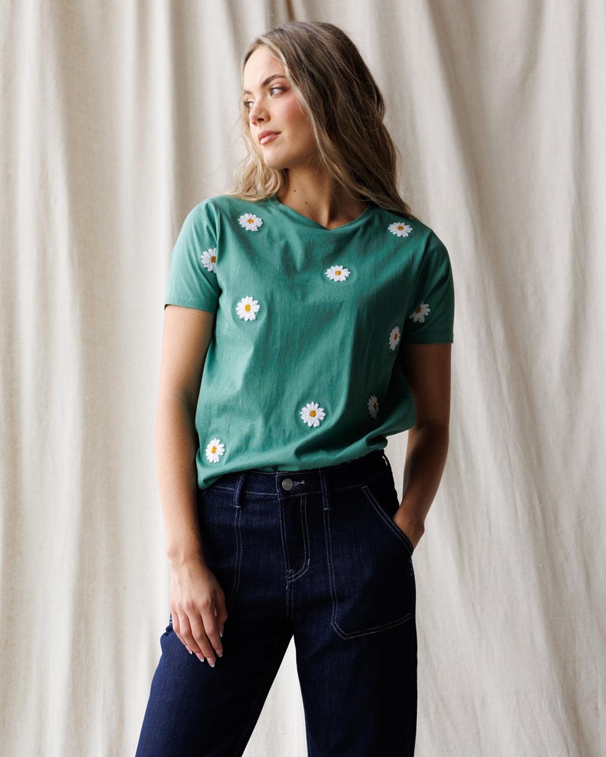 Women's teal tee with white daisy embroidery, crew neck short sleeves.